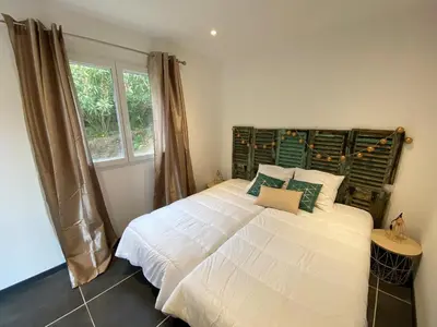 a bedroom with a large white bed with a window at Villa Dominique Porto-Vecchio proche des plages in Porto-Vecchio