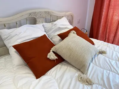 a bed with two pillows on top of it at Villa Dominique Porto-Vecchio proche des plages in Porto-Vecchio