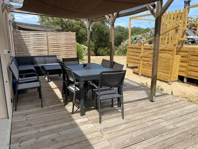 a patio with a table and chairs on a deck at Villa Dominique Porto-Vecchio proche des plages in Porto-Vecchio