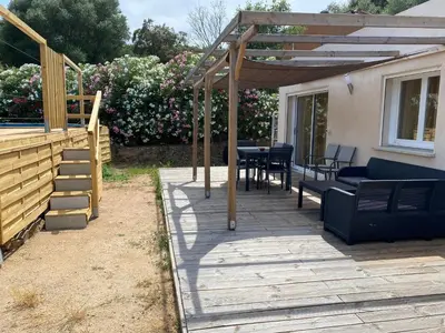 a patio with a table and chairs under a pergola at Villa Dominique Porto-Vecchio proche des plages in Porto-Vecchio