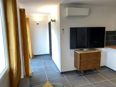 a living room with a flat screen tv on a wall at Villa Dominique Porto-Vecchio proche des plages in Porto-Vecchio