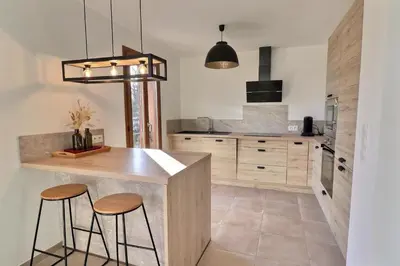 a kitchen with a counter and two stools at Maison U CASTAGNU in Santa-Reparata-di-Balagna