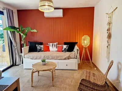 a living room with a couch and a table at Mini Villa 69 - Piscine chauffée in Serra-di-Ferro