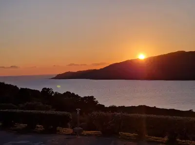 a sunset over a body of water with the sun setting at Mini Villa 69 - Piscine chauffée in Serra-di-Ferro