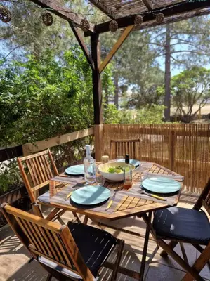 a wooden table and chairs on a patio at Mini Villa 69 - Piscine chauffée in Serra-di-Ferro