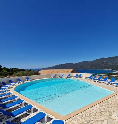 a large swimming pool with lounge chairs and a beach at Mini Villa 69 - Piscine chauffée in Serra-di-Ferro