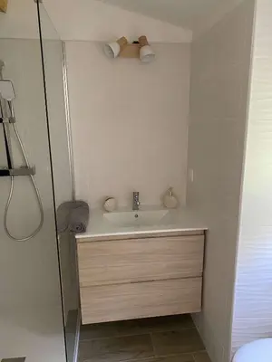 a white bathroom with a sink and a shower at Bel appartement au coeur du village de Sartene in Sartène