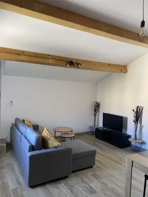 a living room with a blue couch and a tv at Bel appartement au coeur du village de Sartene in Sartène