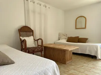 a room with two beds and a table and a chair at Maison de Lou in Porticcio