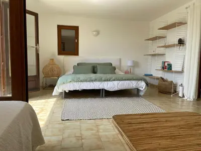 a bedroom with a bed in the middle of a room at Maison de Lou in Porticcio