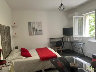 a bedroom with a bed with a red blanket and a desk at Studio CORTE in Corte