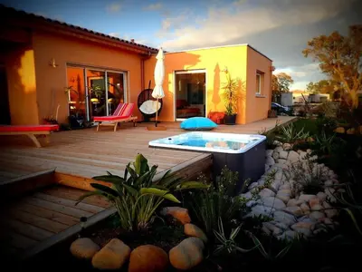 a backyard with a hot tub on a wooden deck at NEW Villa with JACUZZI, near St Cyprien beach in Lecci