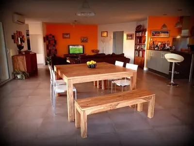 a wooden table and chairs in a living room at NEW Villa with JACUZZI, near St Cyprien beach in Lecci