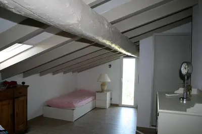 a bedroom with a bed and a ceiling with beams at Maison golfe d'Ajaccio: vue mer in Pietrosella
