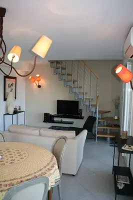 a living room with white furniture and a staircase at Maison golfe d'Ajaccio: vue mer in Pietrosella