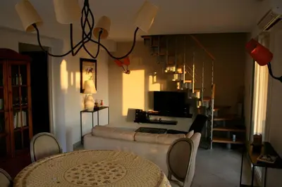 a living room with a television and a table and chairs at Maison golfe d'Ajaccio: vue mer in Pietrosella