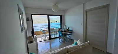 a living room with a couch and a table with a view at T2 de Standing Coté Plage, les pieds dans l'eau in Propriano