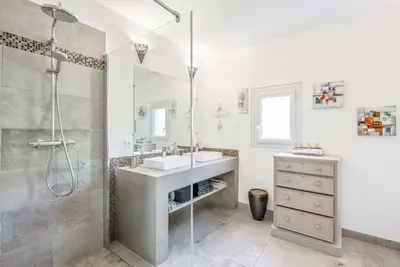 a white bathroom with a sink and a shower at Villa des Orangers - Villa vue mer avec piscine in Grosseto-Prugna
