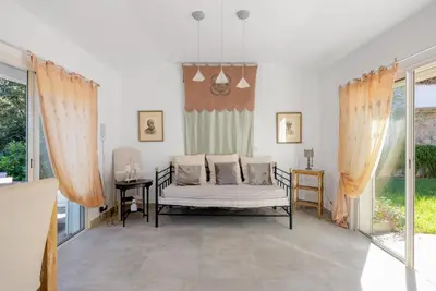 a living room with a couch and some windows at Villa des Orangers - Villa vue mer avec piscine in Grosseto-Prugna