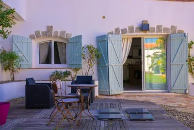 a patio with chairs and a table in front of a building at Villa des Orangers - Villa vue mer avec piscine in Grosseto-Prugna