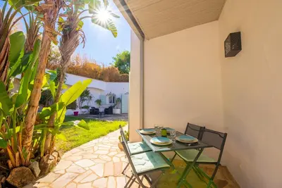 a table and chairs sitting on a patio with a view at Villa des Orangers - Villa vue mer avec piscine in Grosseto-Prugna