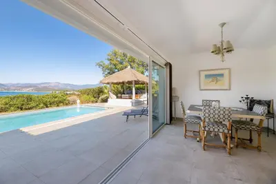 a dining room with a table and a swimming pool at Villa des Orangers - Villa vue mer avec piscine in Grosseto-Prugna