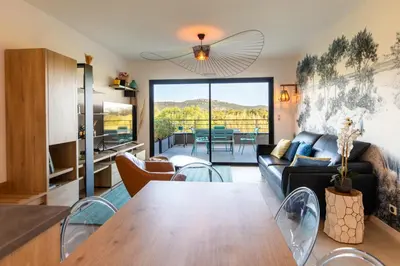 a living room with a table and a couch at La Clé Terrasse, Proche port,centre, parking,clim in Porto-Vecchio
