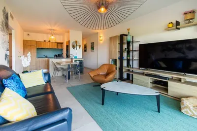 a living room with a large flat screen tv at La Clé Terrasse, Proche port,centre, parking,clim in Porto-Vecchio
