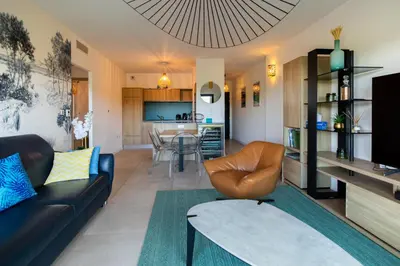 a living room with a couch and a table at La Clé Terrasse, Proche port,centre, parking,clim in Porto-Vecchio