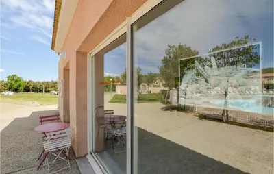 a window of a building with chairs and tables at Lovely Apartment In Sta Maria Poggio in Moriani Plage