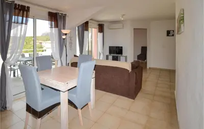 a living room with a table and chairs and a bed at Lovely Apartment In Sta Maria Poggio in Moriani Plage