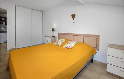 a bedroom with a large yellow bed with two pillows at Lovely Apartment In Sta Maria Poggio in Moriani Plage