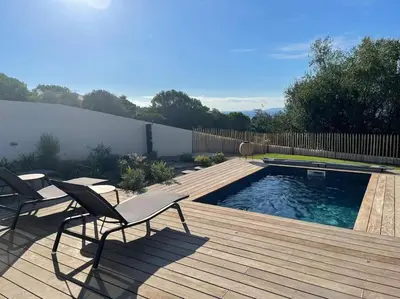 a deck with two chairs and a swimming pool at Maison villa 3 chambres plage Agosta proche Porticcio in Pietrosella