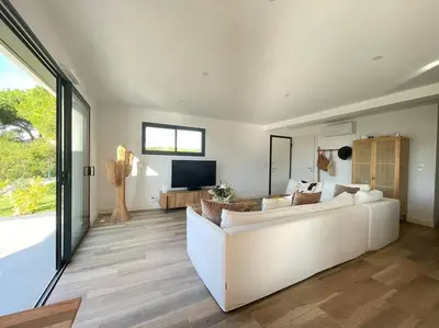 a living room with a white couch and a television at Maison villa 3 chambres plage Agosta proche Porticcio in Pietrosella