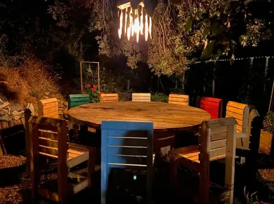 a wooden table with chairs and a chandelier at Charmant T2 proche de Corte in Soveria