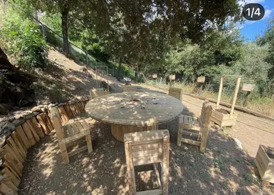 a wooden table and chairs and a table and some trees at Charmant T2 proche de Corte in Soveria