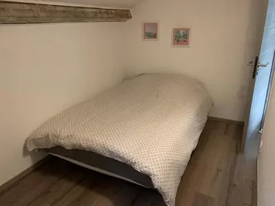 a bed in a corner of a room at Prunete - Appartement - 2 personnes - Piscine in Cervione