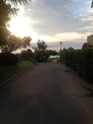 an empty street with the sun setting in the distance at Prunete - Appartement - 2 personnes - Piscine in Cervione
