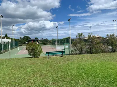 a park with a bench on a tennis court at Prunete - Appartement - 2 personnes - Piscine in Cervione