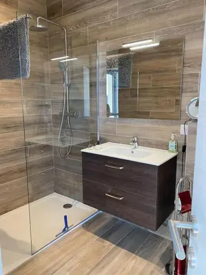 a bathroom with a sink and a glass shower at Spacieux appart- 6PERS- VUE MER- 2 min de la plage in Propriano