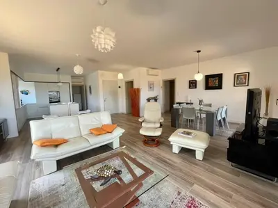 a living room with a white couch and a table at Spacieux appart- 6PERS- VUE MER- 2 min de la plage in Propriano