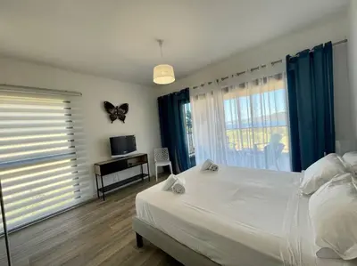 a bedroom with a bed and a desk and a window at Spacieux appart- 6PERS- VUE MER- 2 min de la plage in Propriano