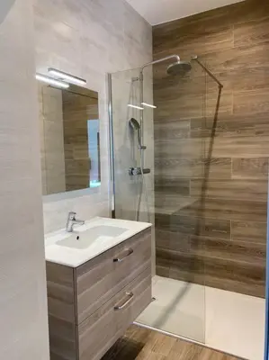 a bathroom with a sink and a glass shower at Spacieux appart- 6PERS- VUE MER- 2 min de la plage in Propriano