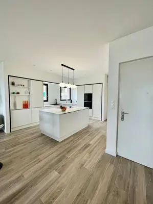 a white kitchen with a white island in a room at Spacieux appart- 6PERS- VUE MER- 2 min de la plage in Propriano