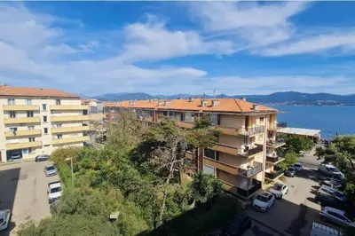 an apartment building with a parking lot next to the water at Spacious apartment with sea view in Ajaccio