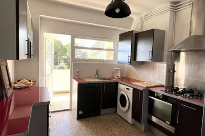 a kitchen with a sink and a washing machine at Spacious apartment with sea view in Ajaccio