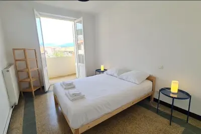 a bedroom with a bed with two tables and a window at Spacious apartment with sea view in Ajaccio