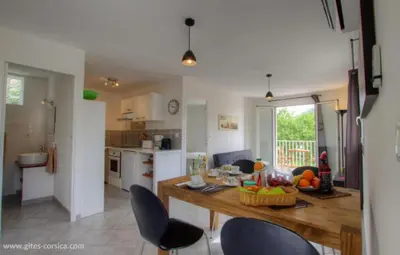a kitchen with a table and chairs in a room at Village Cargese 1 in Cargèse