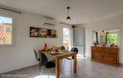 a dining room with a wooden table and chairs at Village Cargese 1 in Cargèse
