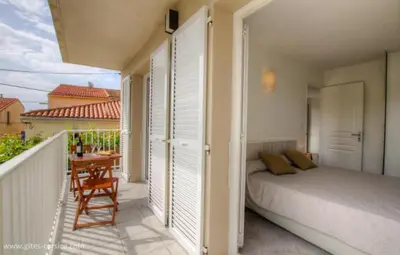 a bedroom with a bed and a table on a balcony at Village Cargese 1 in Cargèse